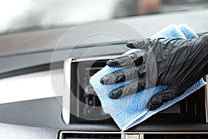 This image is a picture of wiping the car by a blue microfiber cloth with hand wearing gloves