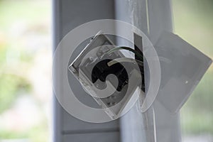 3-pin plug socket adapter hanging out from the wall