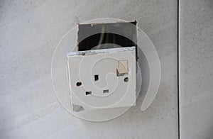 3-pin plug socket adapter hanging out from the wall