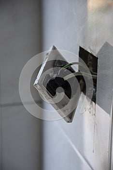 3-pin plug socket adapter hanging out from the wall