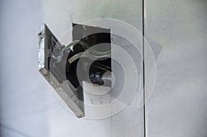 3-pin plug socket adapter hanging out from the wall