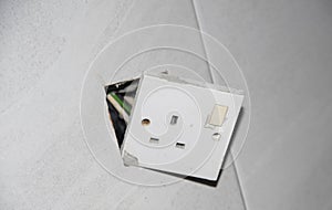 3-pin plug socket adapter hanging out from the wall