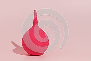 Image of a pink rubber enema on a pink isolated background. Concept of medicine and pharmaceutical products, body detox. Place for