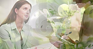 Image of plants over caucasian woman consulting psychologist