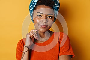 Image of pleased african american woman posing and looking at camera