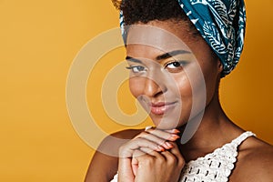 Image of pleased african american woman posing and smiling on camera