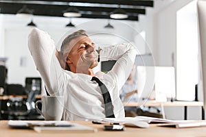 Image of Pleased middle aged business man relaxing photo