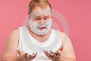 Image of plump shocked amazed man with shaving foam on face. Looking at camera.