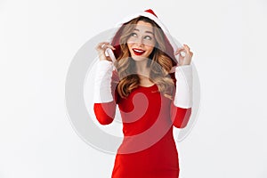 Image of positive girl 20s wearing Christmas red dress standing, isolated over white background