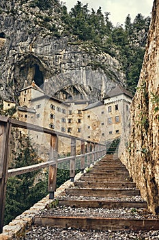 Image of Predjamski castle with stairs in the foreground