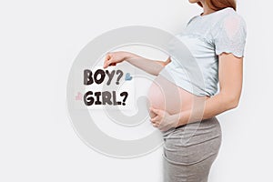Image of a pregnant woman holding a paper near the pregnant belly, with a boy or girl issues
