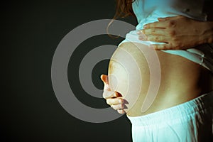 Image of pregnant woman touching her belly with