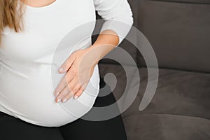 Image of pregnant woman touching her belly with hands