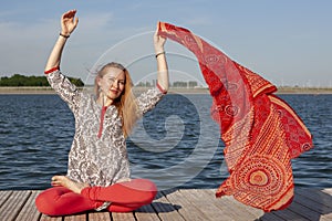 An image of a pretty woman doing yoga at the lake