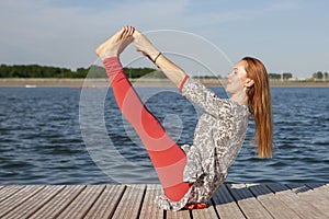 An image of a pretty woman doing yoga at the lake