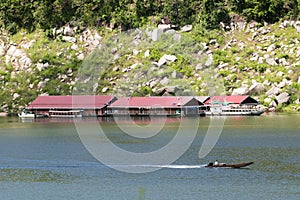 Image of raft floating on the water and long tail boat