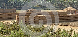 This is an image of raw bricks stacks in india .