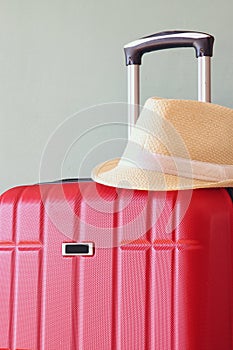Image of red elegant travel luggage and fedora hat in front of sea. travel and vacation concept