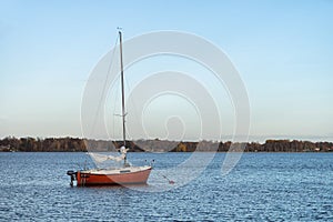 Image of red wooden boat on the autumn lake