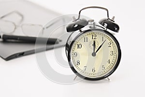 Image of retro alarm clock and business objects