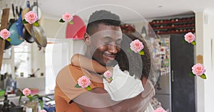 Image of roses over african american father hugging his daughter