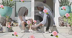 Image of roses over african american father tying shoes of his daughter