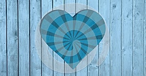 Image of rotating blue striped background over heart shapes hole in blue wooden surface