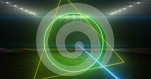 Image of rotating neon shapes and lights over floodlit sports field