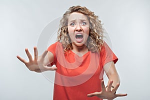 Image of scared blonde girl. Fright, phobia and facial expression concept. Studio shot, white background, isolated