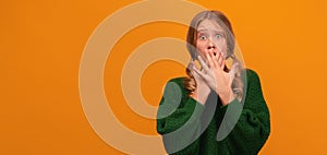 Image of scared blonde teen covering her mouth with hands. Fright, horror concept. Copy space, yellow background