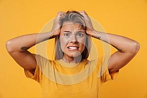 Image of scared woman looking at camera and grabbing her head