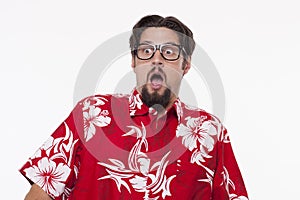 Image of a scared young man in Hawaiian shirt standing against w