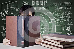 Schoolgirl reads a book with scribbles background