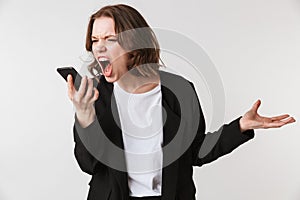 Screaming agressive young woman standing isolated