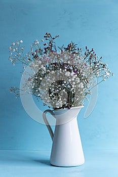 Vase with flowers on blue background. photo