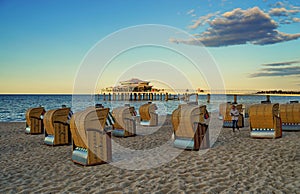 Image of several chairs on sand with Timmendorfer Strand on the Baltic Sea on the background photo