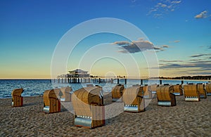 Image of several chairs on sand with Timmendorfer Strand on the Baltic Sea on the background photo