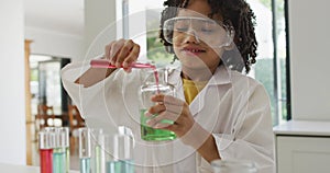 Image of shapes over african american schoolboy at science class