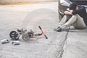 Image of shocked and scared driver after accident involved Kid`s bike and helmet lying on the road on pedestrian crossing after