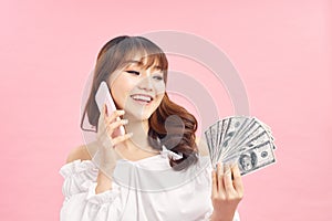 Image of a shocked surprised screaming young pretty woman posing isolated over pink wall background using mobile phone holding