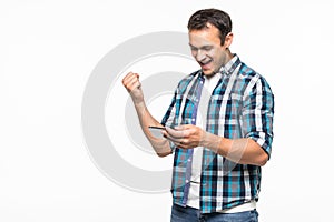 Portrait of shocked young man using mobile phone standing isolated over white background