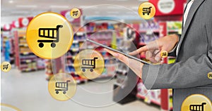 Image of shopping icons over woman using tablet