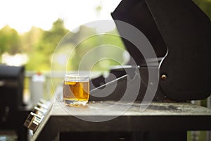 Image of a shot of whiskey on a grille on a porch