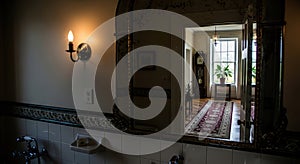 bathroom mirror reflects an elegant hallway view