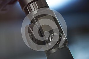 Close-up of a digital control panel with joystick and display screen on a black electronic device