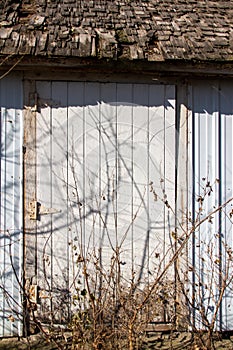 Old barn wall with newer white siding and original wood shingles