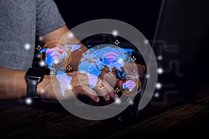 The image shows global internet connectivity via digital technology. Hands are typing laptop