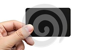 A hand holding a sleek black rectangular device against a plain background