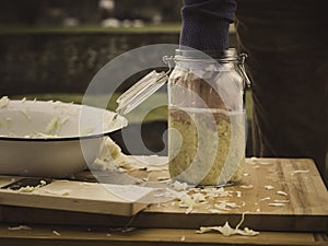 Pack homemade sauerkraut into a jar photo