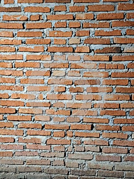 This image shows a wall made of red clay bricks. The bricks are arranger in a staggered pattern.